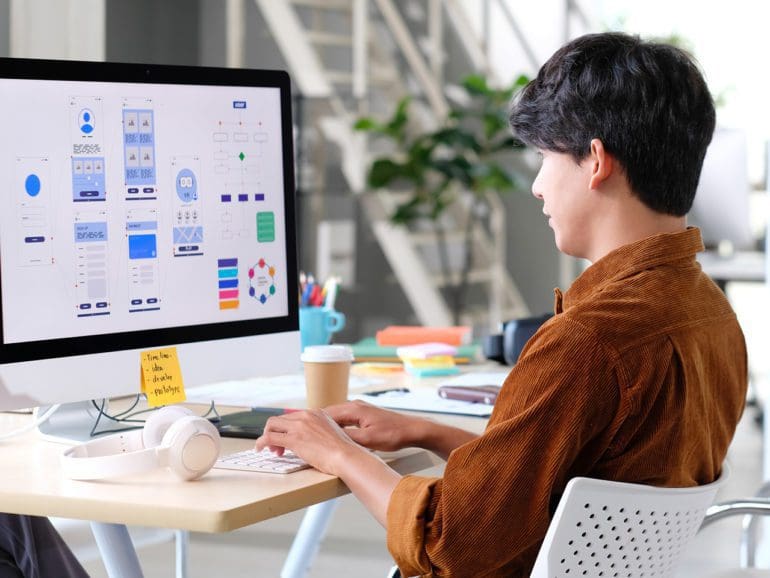 Website designer, Creative planning phone app development template layout framework wireframe design, User experience concept, Young asian man UX designer working on smartphone application at office