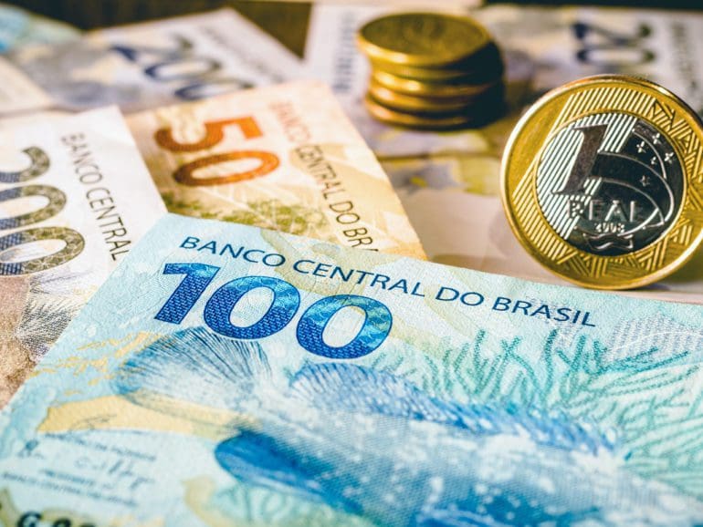 In this photo illustration being displayed one hundred and two hundred reais bills and a one reais coin highlighted. The Real is the current money in Brazil.