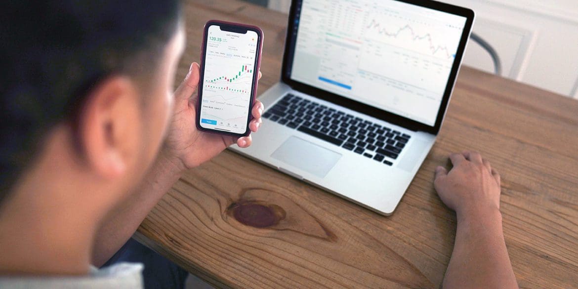 man looking at laptop and phone