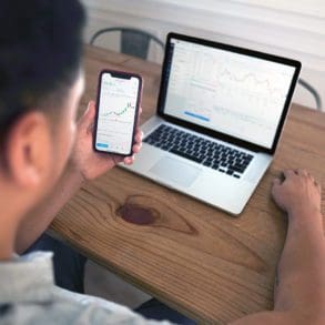 man looking at laptop and phone