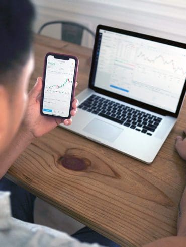 man looking at laptop and phone