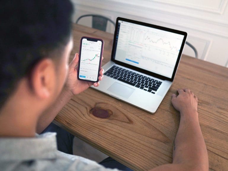 man looking at laptop and phone