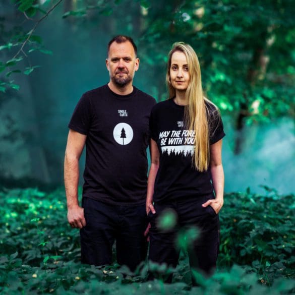 man and women standing in forest