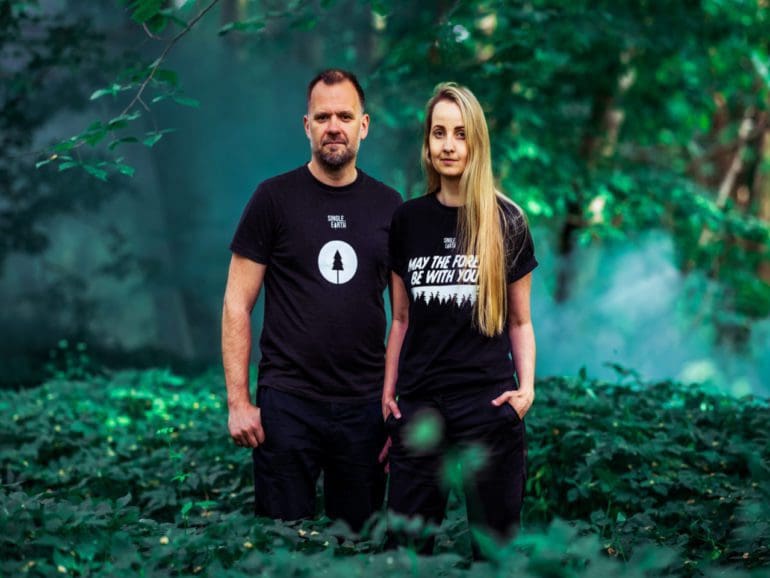 man and women standing in forest