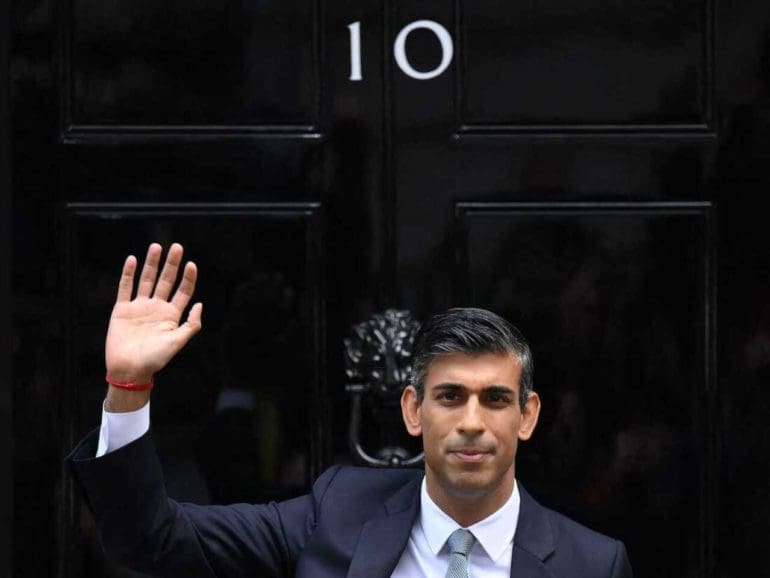 Britain's newly appointed Prime Minister Rishi Sunak waves as he poses outside to door to 10 Downing Street in central London, on October 25, 2022, after delivering his first speech as prime minister. - Rishi Sunak was on Tuesday appointed as Britain's third prime minister this year, after outgoing leader Liz Truss submitted her resignation to King Charles III. (Photo by Daniel LEAL / AFP) (Photo by DANIEL LEAL/AFP via Getty Images)
