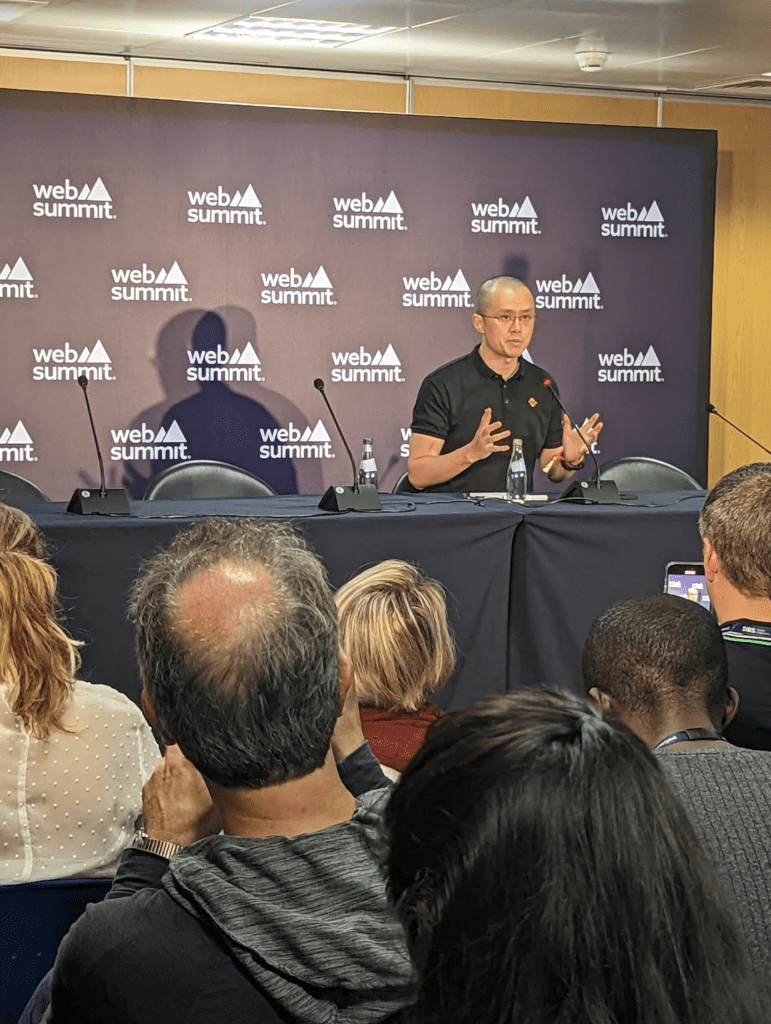 man in a press confrence, hes wearing a black top 