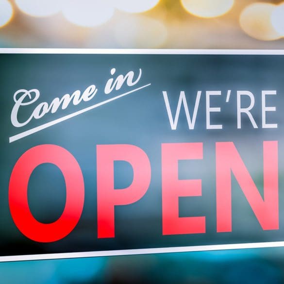 Small Business Store Front With "Come In We're Open" Sign Hanging On Window - Small Business Concept