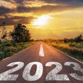 Empty asphalt road and New year 2023 concept. Driving on an empty road to Goals 2023 with sunset.