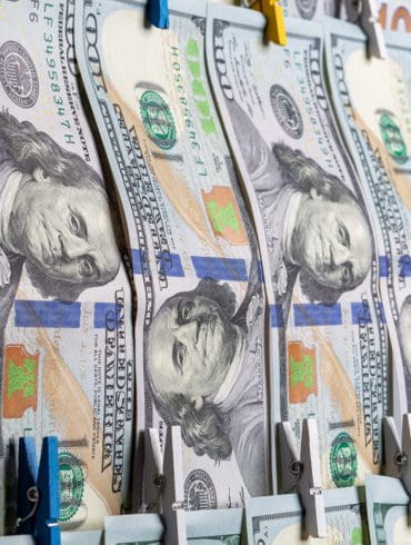 Anti-Money Laundering concept. AML. US Dollars hanging on ropes