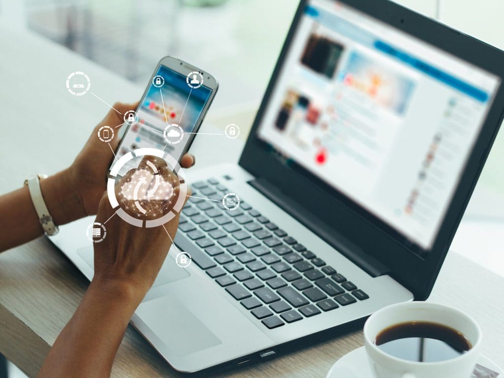 Young businesswoman working on his smartphone and laptop in the office, select the icon cloud on the virtual display.Concept digital technology and cloud technology.vintage color tones