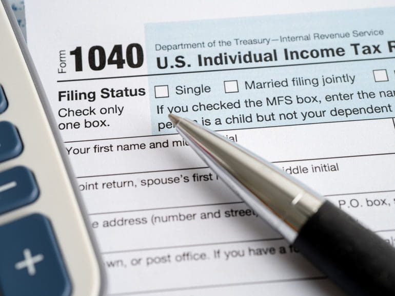 Tax Return form 1040 with USA America flag and dollar banknote, U.S. Individual Income.