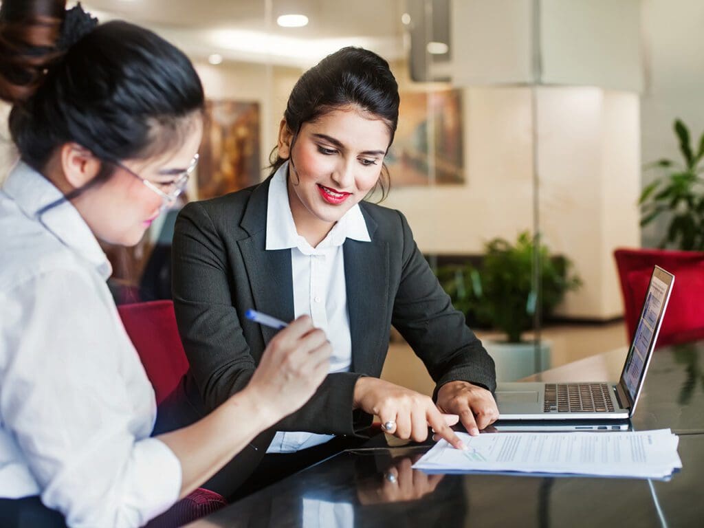 Indian female agent helping client sign the application document