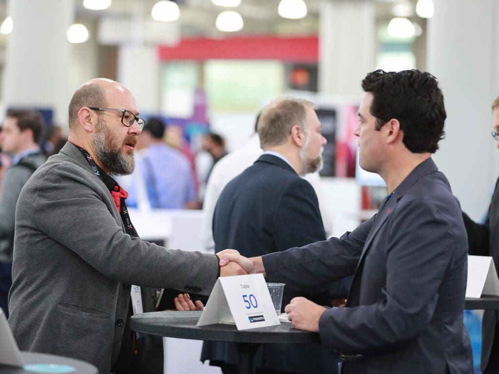 Handshake at Fintech Nexus networking table in 2022.