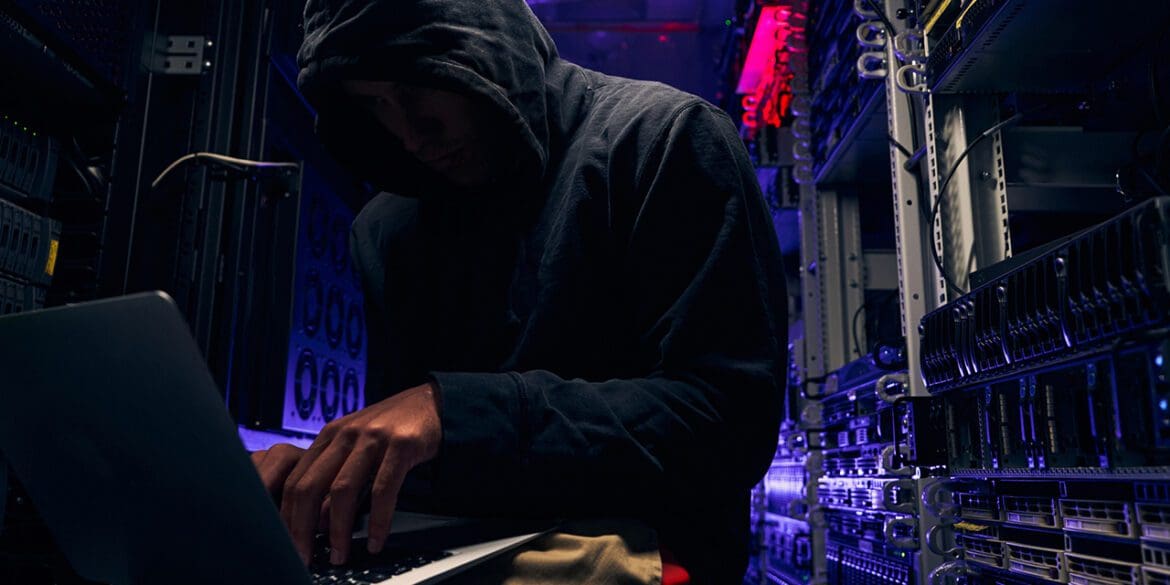 Expert cybercriminal gaining illegal access to computer network in data center