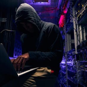 Expert cybercriminal gaining illegal access to computer network in data center