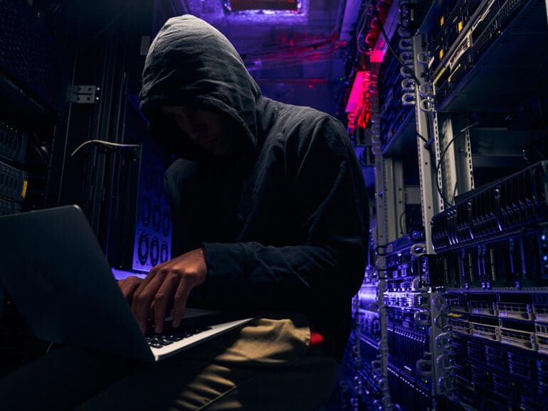 Expert cybercriminal gaining illegal access to computer network in data center