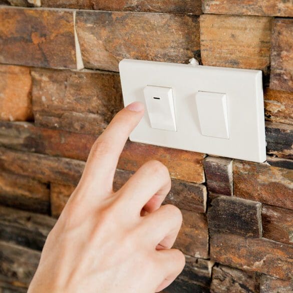 Human finger turning off the light switch - green earth and energy saving concept