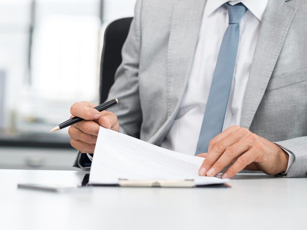 Senior analyst managing business accounts. Close up of a senior businessman hands checking final report before submission. Close up of hands of leadership signing business contract.