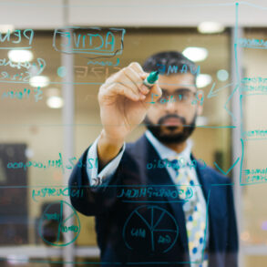 Anish Dhanjee writes his ideas for EqualSeat on a white board