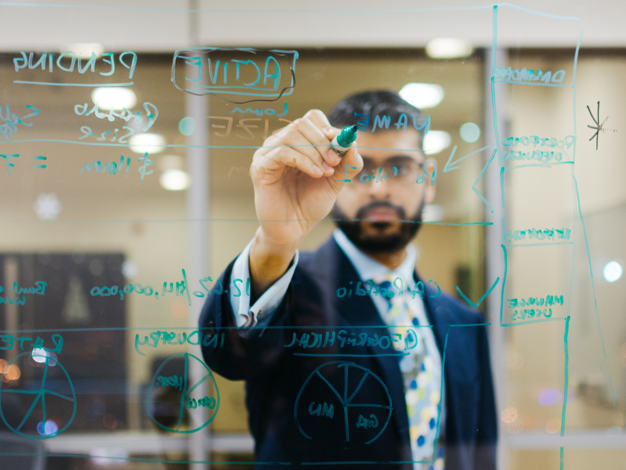 Anish Dhanjee writes his ideas for EqualSeat on a white board